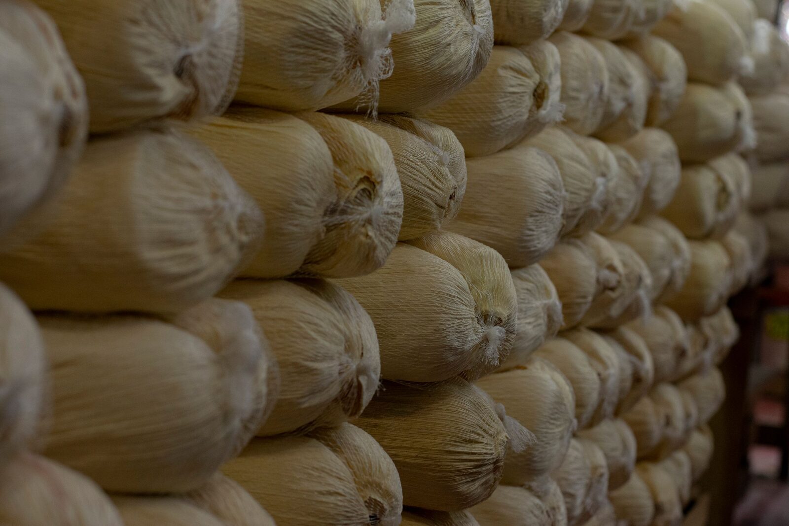 Stacked bags of branded hybrid corn seed in an agricultural supply warehouse
